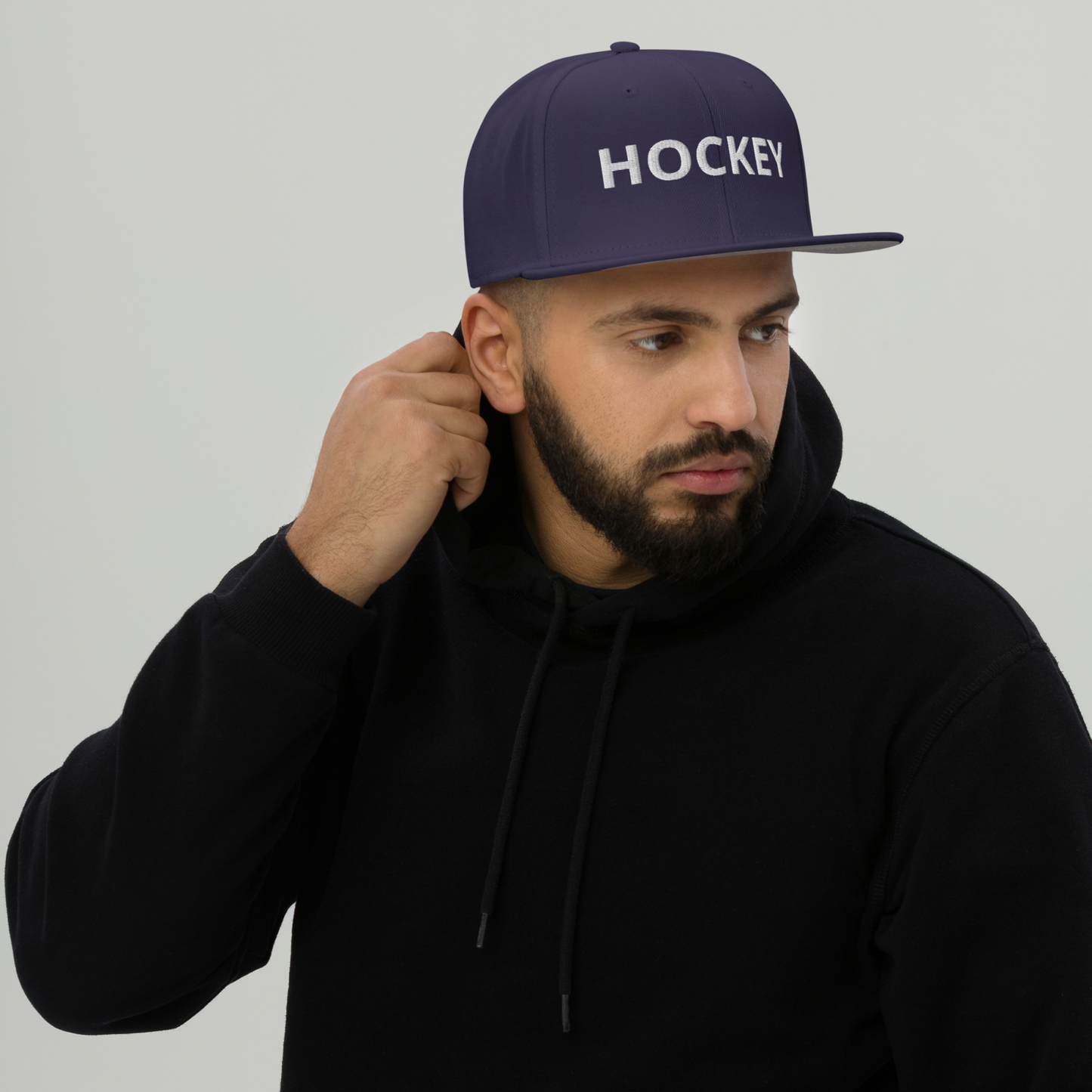 HOCKEY Snapback-Cap in Dunkelblau mit Kunststoff-Schnappverschluss und grauem Schirmunterseite, 85% Acryl, 15% Wolle, verstellbar für 55-60 cm Kopf.